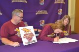 Katelyn Cole, signing her letter-of-intent, is flanked by father Charles and mom Tricia Rettig.